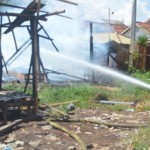 Petugas Damkar mencoba menjinakkan api akibat kebakaran bedeng bedeng pekerja proyek RSUD Buleleng