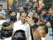 Presiden Joko Widodo melayani ajakan selfi masyarakat saat meresmikan pasar Badung di Denpasar, Bali pada Jumat, 22 Maret 2019 - foto: Koranjuri.com