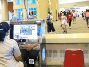 Petugas melakukan deteksi suhu tubuh terhadap wisatawan melalui body thermo scanner di terminal kedatangan internasional Bandara Ngurah Rai, Bali - foto: Istimewa
