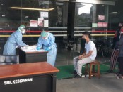 Petugas medis ber APD lengkap melakukan screening test terhadap setiap pengunjung maupun petugas yang hendak memasuki area Rumah Sakit Sanjiwani Gianyar, Minggu (12/4/2020) pagi - foto: Catur/Koranjuri.com
