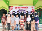 Anggota PMR Wira SMK Kesehatan Purworejo, berfoto bersama dengan para peserta Guru Tonggo di mushola Dusun Onggopaten, Desa Mudalrejo, Loano, Minggu (18/04/2021) - foto: Sujono/Koranjuri.com