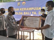 Penyerahan piagam penghargaan oleh Ketua SMSI Provinsi Bali kepada Kabid Humas Polda Bali Kombes Pol Samsi pada pelatihan 'Peningkatan Kemampuan PID Jajaran Polda Bali TA. 2021' - foto: Koranjuri.com