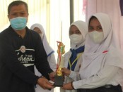 Kepala SMK Kesehatan Purworejo Nuryadin, S.Sos, M.Pd, saat menyerahkan piala pada para pemenang lomba Invitasi PMR Madya tingkat Kabupaten Purworejo, Senin (28/02/2022) - foto: Sujono/Koranjuri.com