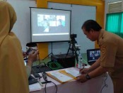 Kepala SMK Kesehatan Purworejo Nuryadin, S.Sos, M.Pd, saat menandatangani naskah kerjasama (MoU) dengan PT Atensi Akselerasi Indonesia dan PT Saiber Dunia Imaji, Senin (23/05/2022), yang dilakukan secara virtual - foto: Sujono/Koranjuri.com