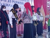 Kepala SMPN 33 Purworejo, Dr Nikmatur Rohmah, M.Pd, saat menyerahkan penghargaan kepada tiga siswa terbaik peraih The Best of the Year, Rabu (15/06/2022) - foto: Sujono/Koranjuri.com