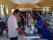 Kepala UPT BLK Dinperinaker Kabupaten Purworejo, Sudarman, S.Sos, saat memantau produksi masker yang dikerjakan oleh alumni siswa BLK, Kamis (9/4/2020) - foto: Sujono/Koranjuri.com