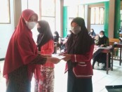 Kepala SMK Batik Purworejo, 
Yati Dwi Puspita Adi, S.Pd, saat menyerahkan bantuan kepada siswa yatim, Kamis (19/08/2021) - foto: Sujono/Koranjuri.com