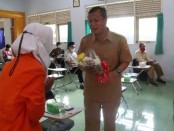 Kepala SMK Kesehatan Purworejo Nuryadin, SSos, MPd, saat menerima setangkai bunga dari siswa di acara Kumpul Bareng Guru, Senin (13/12/2021) - foto: Sujono/Koranjuri.com