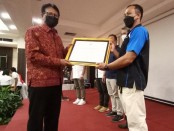 Ketua KONI Provinsi Bali I Ketut Suwandi (kiri) menyerahkan piagam penghargaan kepada wakil 24 cabor prestasi di PON XX Papua - foto: Yan Daulaka
