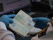 Petugas melakukan pemeriksaan dokumen imigrasi yang masuk Indonesia melalui Bandara I Gusti Ngurah Rai, Bali - foto: Istimewa