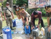 Kepala Satuan Polisi Pamong Praja Provinsi Bali Dewa Rai Dharmadi memimpin pemusnahan barang sitaan arak berbahan baku gula pasir - foto: Koranjuri.com