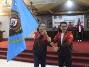 Kadisdikpora Bali IKN Boy Jayawibawa menyerahkan bendera kepada Ketua SIWO PWI Bali Djoko Purnomo - foto: Istimewa